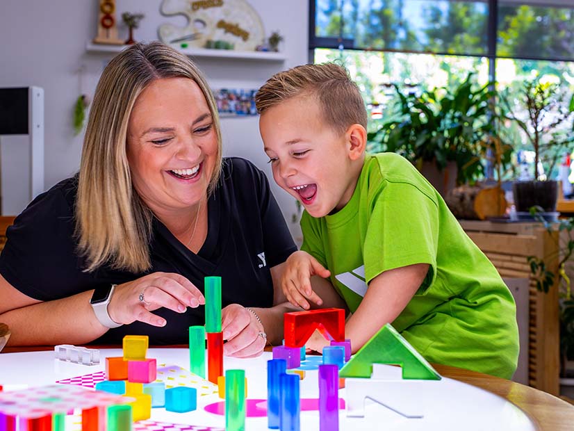 Image of Cranboutrne North ELC educator and a boy playing with blocks
