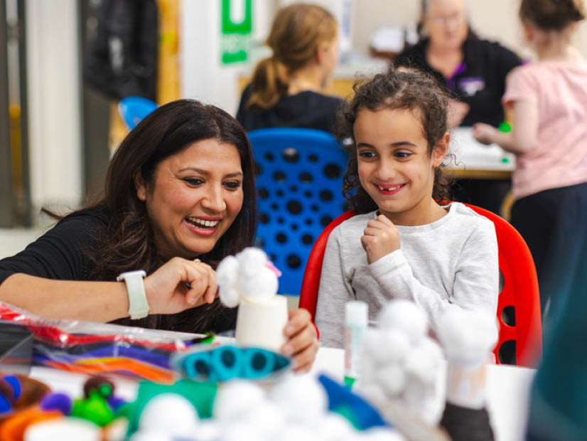 Holiday program educator with girl crafting a snowman