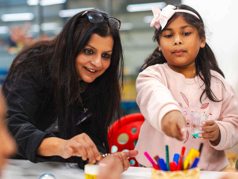 Girls pointing to pencils with OSHC educator